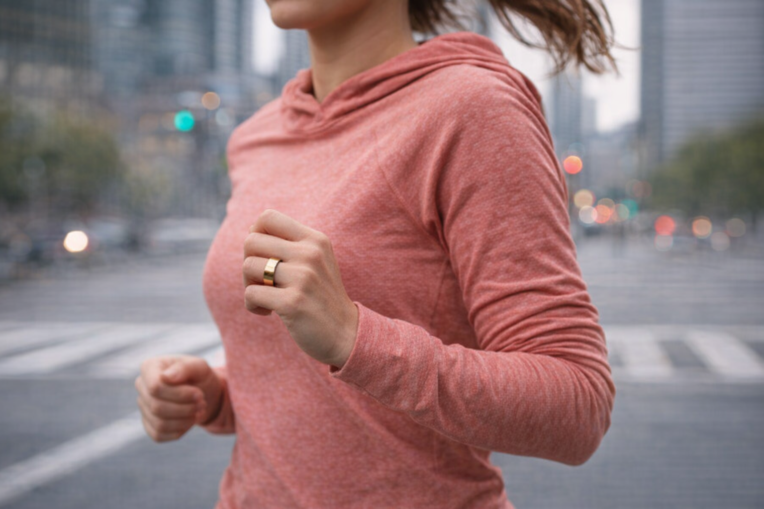 Woman wearing the Movano Evie Ring in Gold while jogging through an urban setting