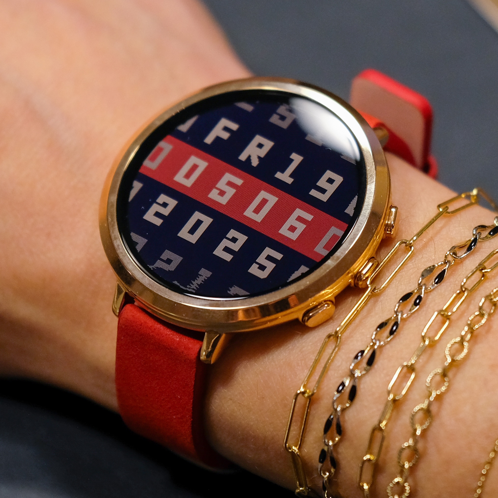Pebble Round 2 Rose Gold close-up on wrist with red leather band and gold bracelets