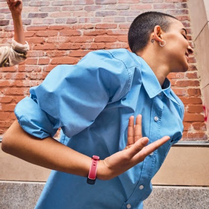 Woman wearing pink Fitbit Inspire 3 dancing outdoors
