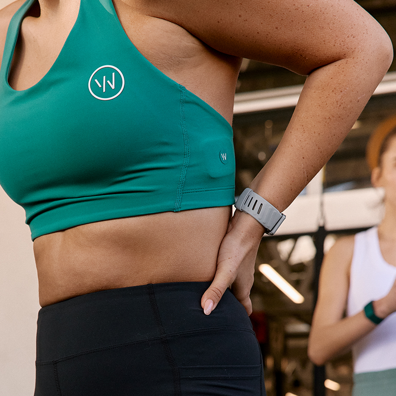 Woman wearing WHOOP 5 on her forearm during a gym session