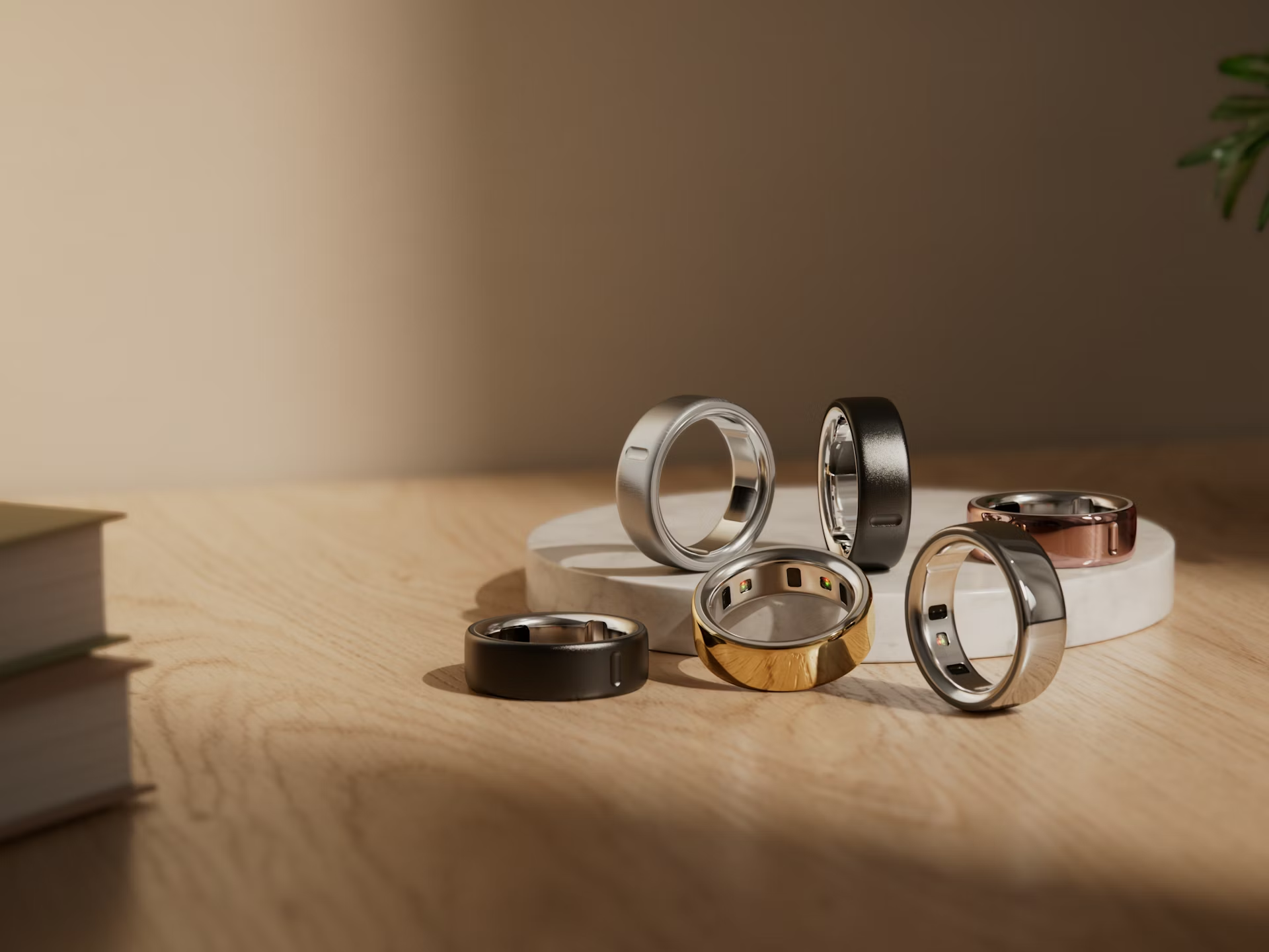Oura Ring 4 all color variants displayed together on wooden surface